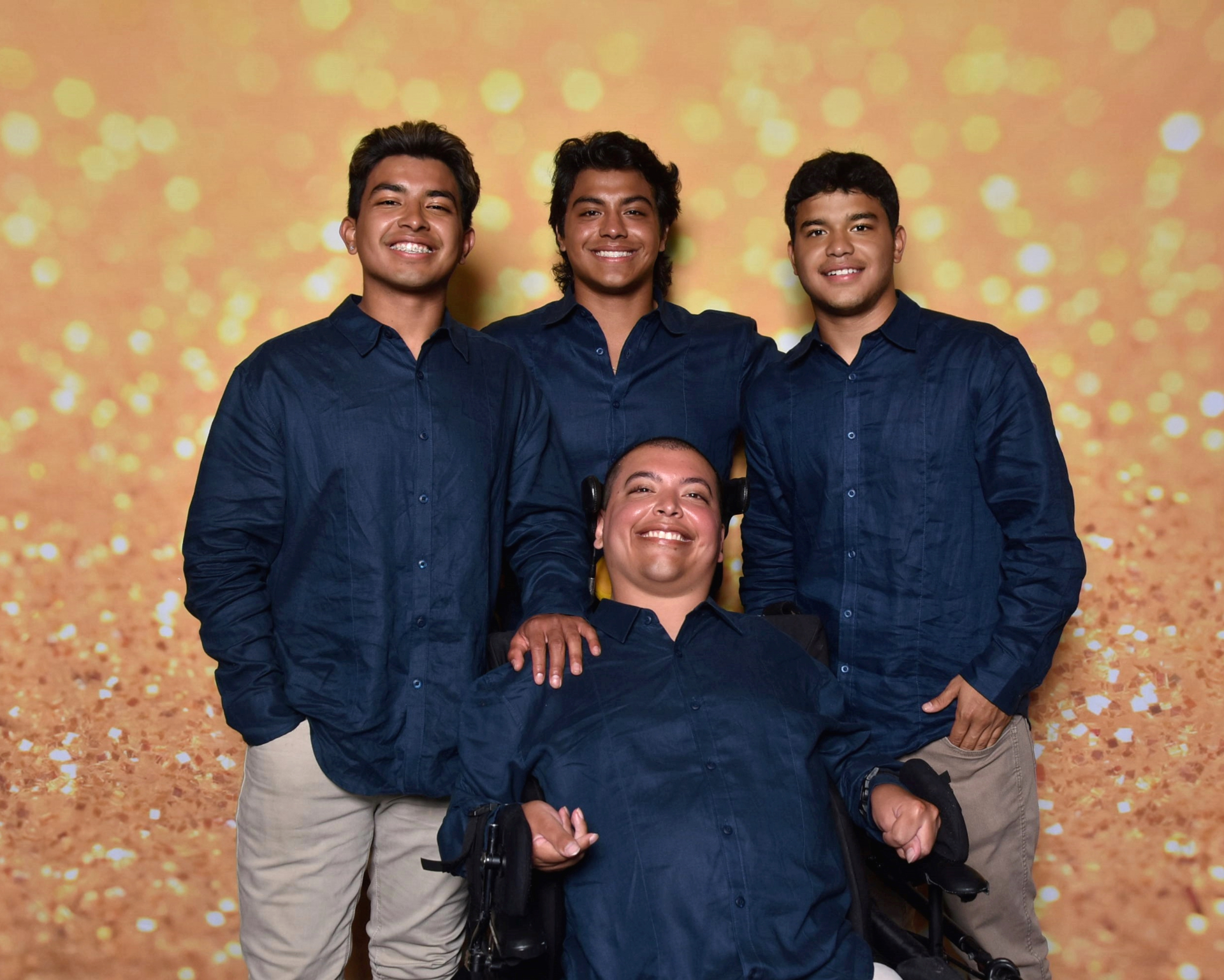 Raul with his three brothers all dressed in navy shirts
