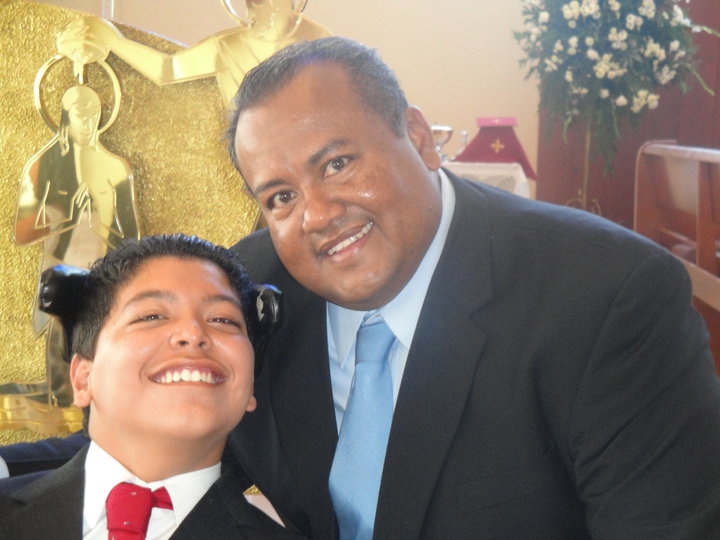 Raul in a suit smiling with his dad Raul at a celebration